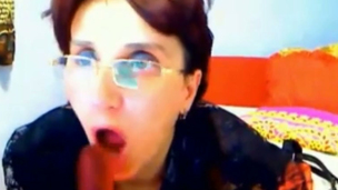 Four eyed mature whore is sucking her big fake penis like a woman possessed