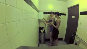 2 harlots are in the public bathroom, licking one another